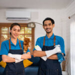 Portrait of young man and woman cleaning service worker work in house. Attractive housekeeper cleaner team wear apron and cleaning messy dirty floor for housekeeping housework and chores in house.